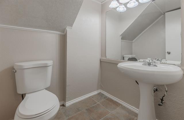 Kitchen with white cabinets, light tile patterned floors, stainless steel appliances, and sink