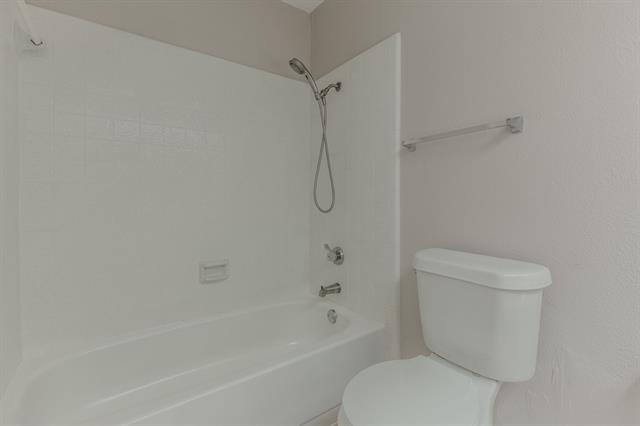 Spare room with a textured ceiling, ceiling fan, and wood-type flooring