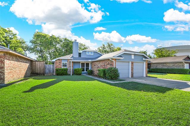 View of front of property with a front yard and a garage
