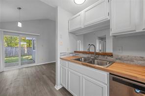 Dining/Kitchen Nook room with dark wood-type flooring, pendant light, door and high vaulted ceiling
