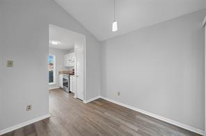 Living room with a newer sliding glass door, textured ceiling, wood-style floors, ceiling fan, and high vaulted ceiling