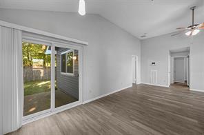 Dining/Kitchen Nook room with dark wood-type flooring, pendant light, sliding glass door and high vaulted ceiling