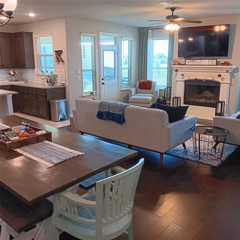 Living room with ceiling fan and dark hardwood flooring